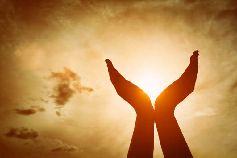 A person 's hands are open in the air as they hold out their arms.